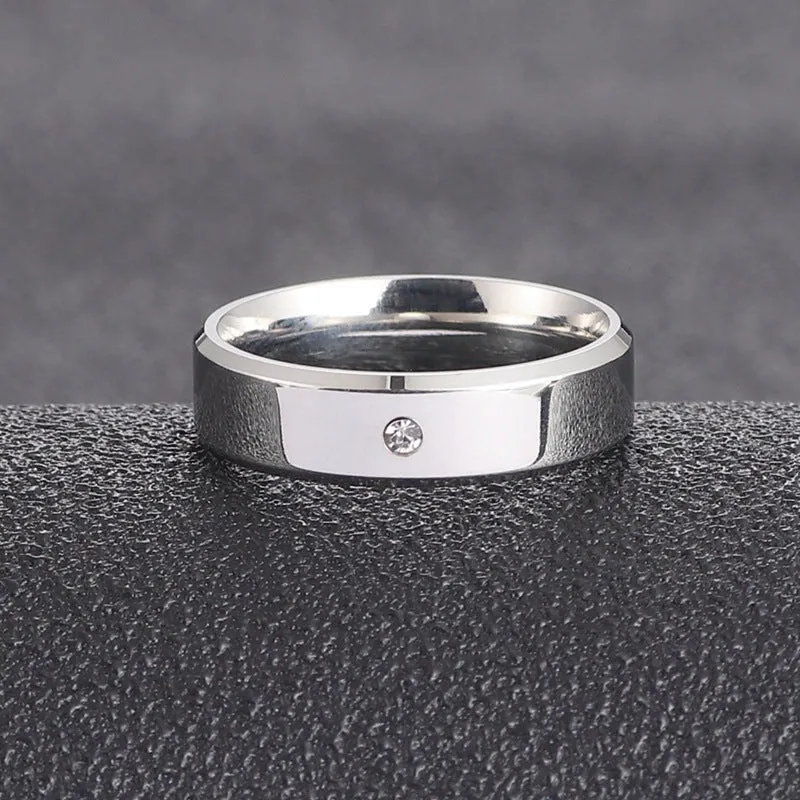 A simple, single-stone, silver-colored couple's ring