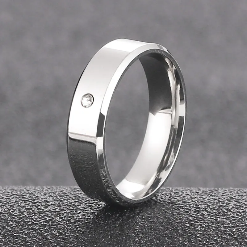 A simple, single-stone, silver-colored couple's ring